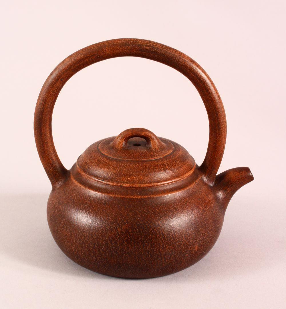 A CHINESE YIXING CLAY TEAPOT, with a fixed moulded: A CHINESE YIXING CLAY TEAPOT, with a fixed moulded handle, the base with a da bin mark, 16cm high.