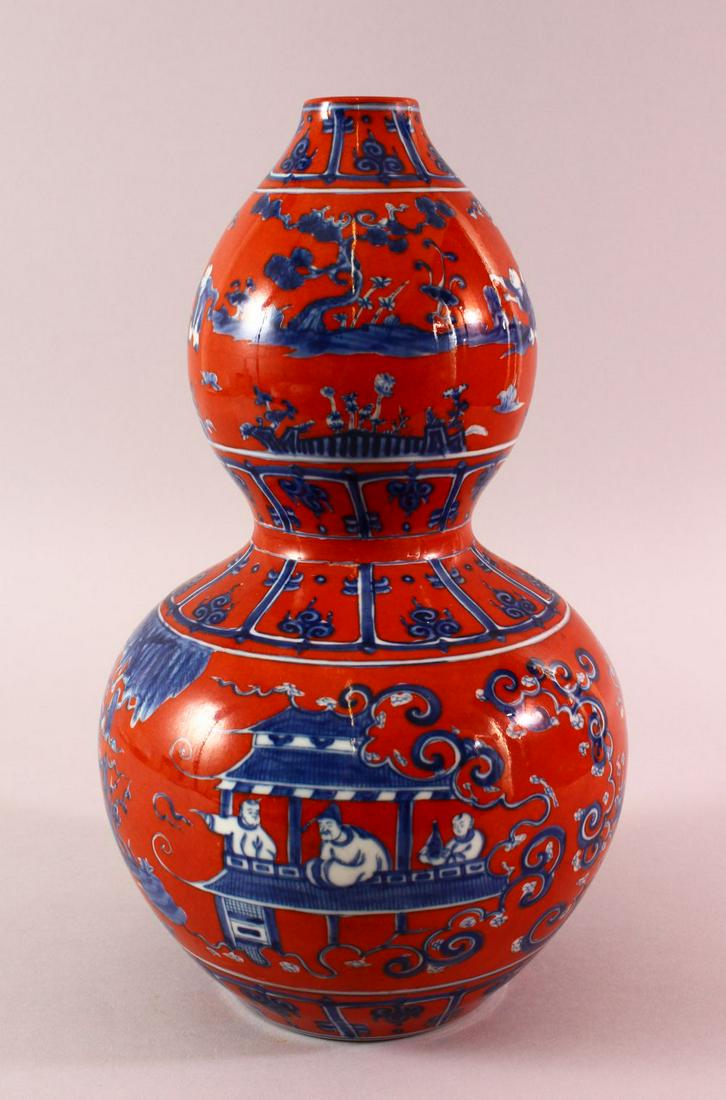 A MING STYLE CORAL RED DOUBLE GOUD PORCELAIN VASE -: A MING STYLE CORAL RED DOUBLE GOUD PORCELAIN VASE - with blue & white decoration of figures and landscapes, base with a six character mark, 33cm
