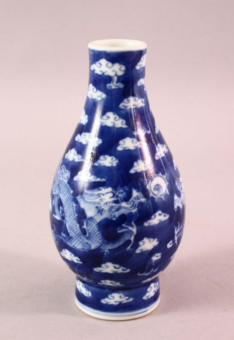 A CHINESE BLUE & WHITE PORCELAIN DRAGON VASE, with: A CHINESE BLUE & WHITE PORCELAIN DRAGON VASE, with clouds and twin dragons, the base with a four character mark, 15.5cm