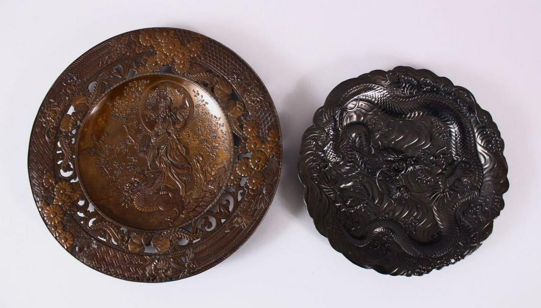 TWO JAPANESE MEIJI PERIOD SOFT METAL / ANTIMONY DISHES: TWO JAPANESE MEIJI PERIOD SOFT METAL / ANTIMONY DISHES - KWANNON - DRAGON, the larger in fine detail depicting kwannon goddess stood amongst cherry blossom and a dragon, 24cm diameter, the other depic