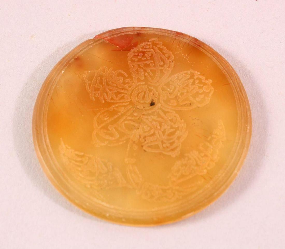AN ISLAMIC CIRCULAR YELLOW AGATE PLAQUE, with engraved: AN ISLAMIC CIRCULAR YELLOW AGATE PLAQUE, with engraved decoration, 6cm diameter.