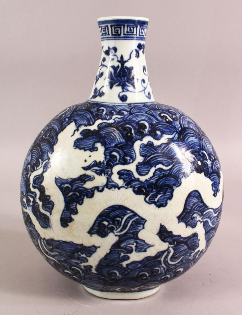 A CHINESE BLUE AND WHITE PORCELAIN MOON FLASK VASE,: A CHINESE BLUE AND WHITE PORCELAIN MOON FLASK VASE, decorated with dragons amongst stylised waves, 29.5cm high, approx. 22cm at the widest point.