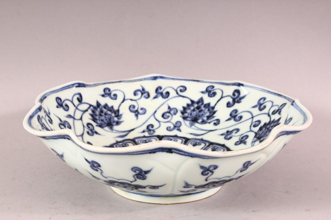A CHINESE MING STYLE BLUE & WHITE PORCELAIN MOULDED: A CHINESE MING STYLE BLUE & WHITE PORCELAIN MOULDED BOWL, decorated with formal lotus rosette, the underside with a six character mark, 25cm