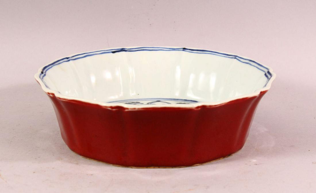 A CHINESE MING STYLE FLAMBE GLAZED BLUE & WHITE: A CHINESE MING STYLE FLAMBE GLAZED BLUE & WHITE PORCELAIN MOULDED DISH - the exterior with a flambe glaze, the interior with yin yang and flora, the base with an incised mark, 19cm