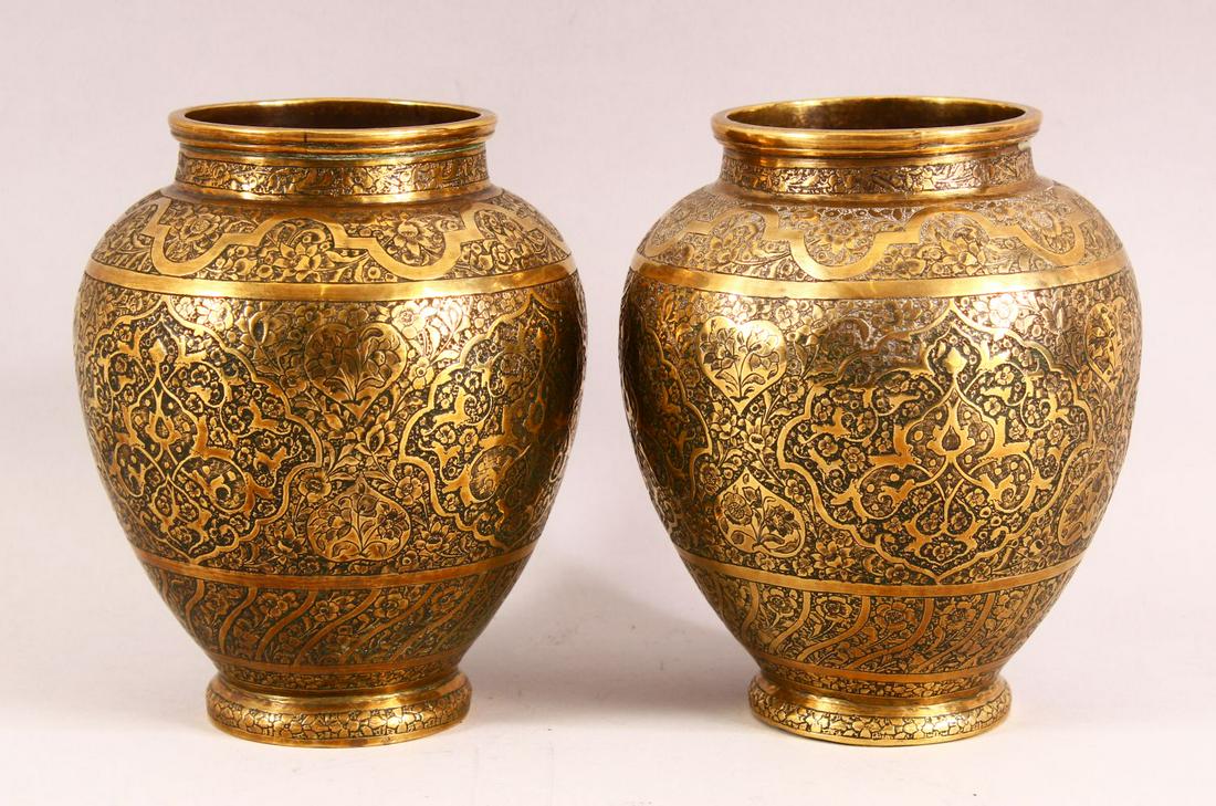A PAIR OF PERSIAN BRASS VASES, with profusely engraved: A PAIR OF PERSIAN BRASS VASES, with profusely engraved and chased decoration, 17cm high.