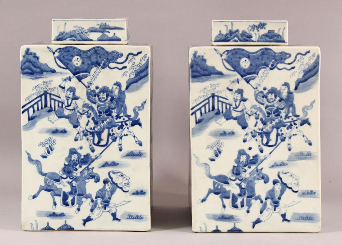 A LARGE PAIR OF CHINESE BLUE & WHITE SQUARE FORMED: A LARGE PAIR OF CHINESE BLUE & WHITE SQUARE FORMED CADDY & COVERS, each decorated with scenes off figures upon horseback, mid battle in landscapes, the bases each with six character marks, 31cm high x