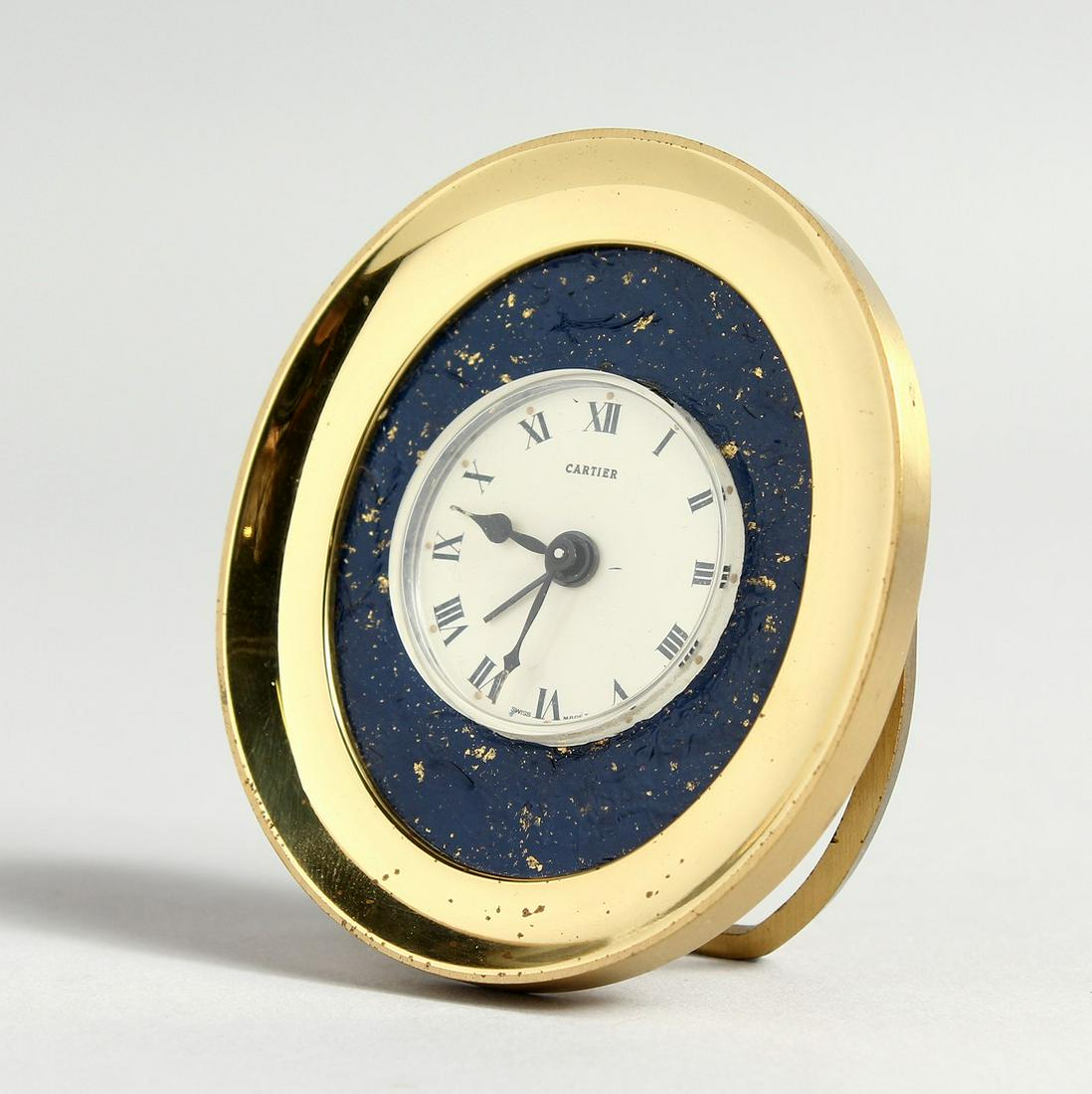 A CARTIER OVAL DESK CLOCK in a red velvet bag and: A CARTIER OVAL DESK CLOCK in a red velvet bag and Cartier box.