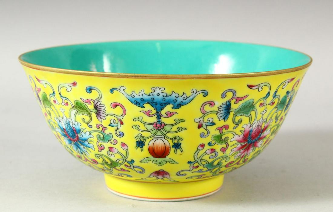 A CHINESE FAMILLE JAUNE PORCELAIN BOWL, the interior: A CHINESE FAMILLE JAUNE PORCELAIN BOWL, the interior with turquoise ground, the exterior painted with flowers and bats, six character mark to base, 16.5cm diameter.