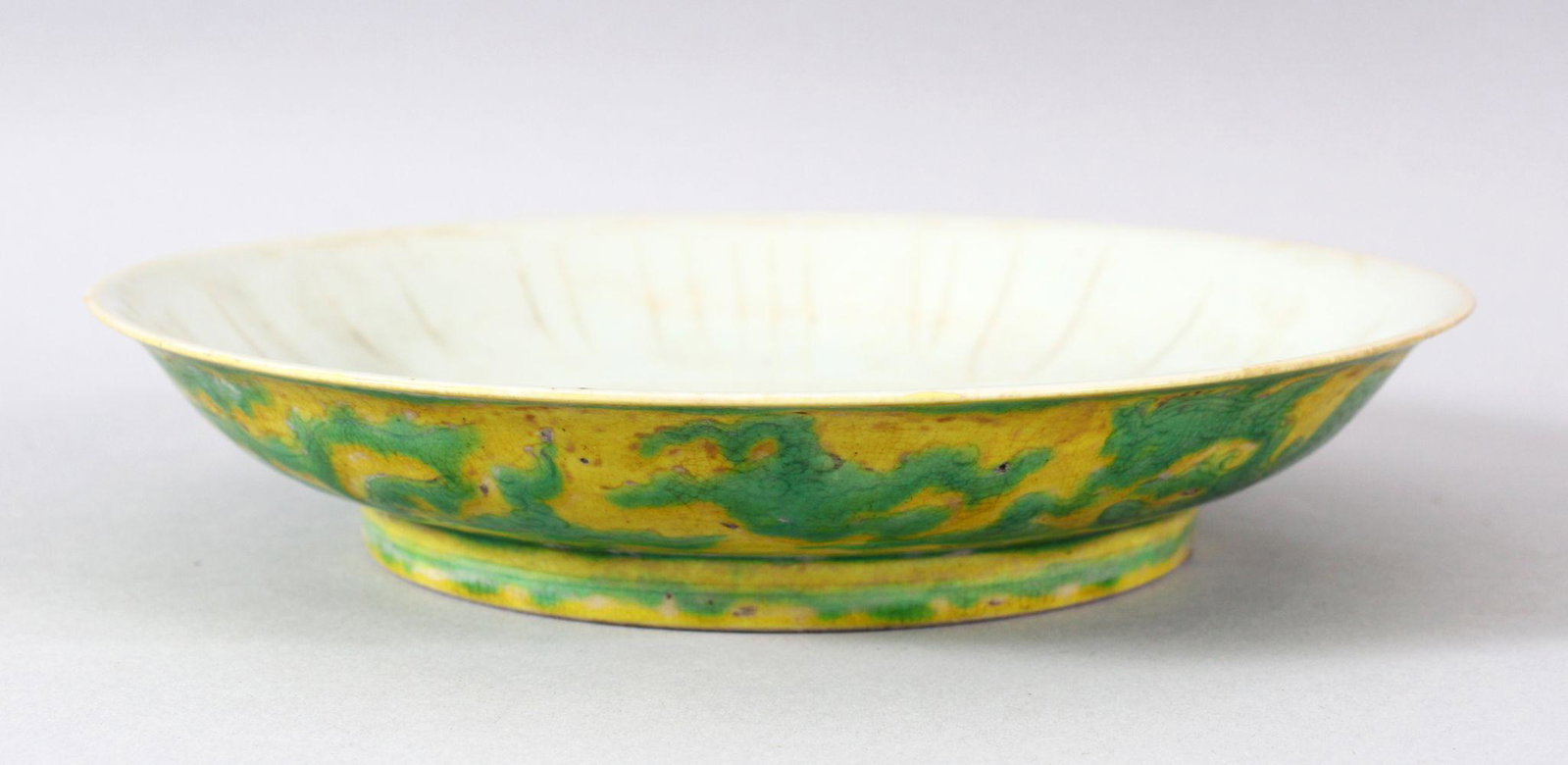 A CHINESE YELLOW GROUND PORCELAIN DRAGON DISH, the base: A CHINESE YELLOW GROUND PORCELAIN DRAGON DISH, the base with six character mark, 20cm diameter.