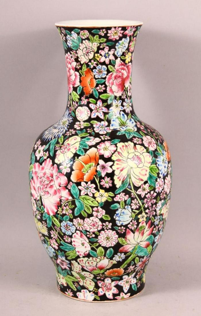 A CHINESE FAMILLE ROSE MILLEFLUER STYLE PORCELAIN VASE,: A CHINESE FAMILLE ROSE MILLEFLUER STYLE PORCELAIN VASE, decorated upon a black ground with profuse display of flora, the base with a seal mark, 31cm.