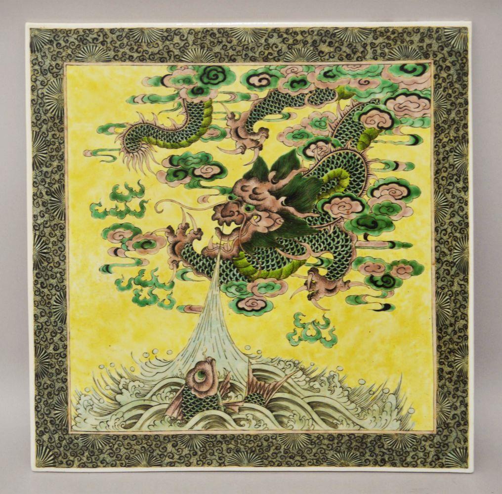 A SUPERB LARGE CHINESE FAMILLE VERTE PORCELAIN PLAQUE,: A SUPERB LARGE CHINESE FAMILLE VERTE PORCELAIN PLAQUE, painted with a dragon and carp on yellow ground, 44.5cm x 45cm.