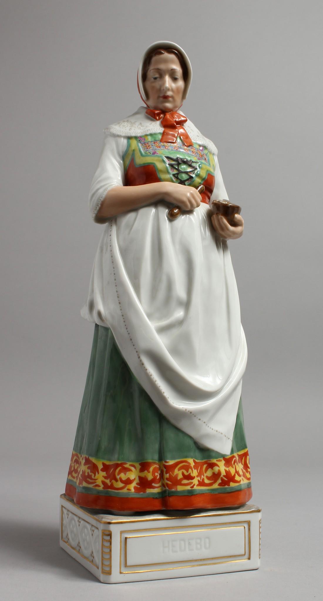 A LARGE COPENHAGEN PORCELAIN FIGURE OF A WOMAN holding: A LARGE COPENHAGEN PORCELAIN FIGURE OF A WOMAN holding a pestle and mortar. Inscribed HEDEBO. 12ins high.