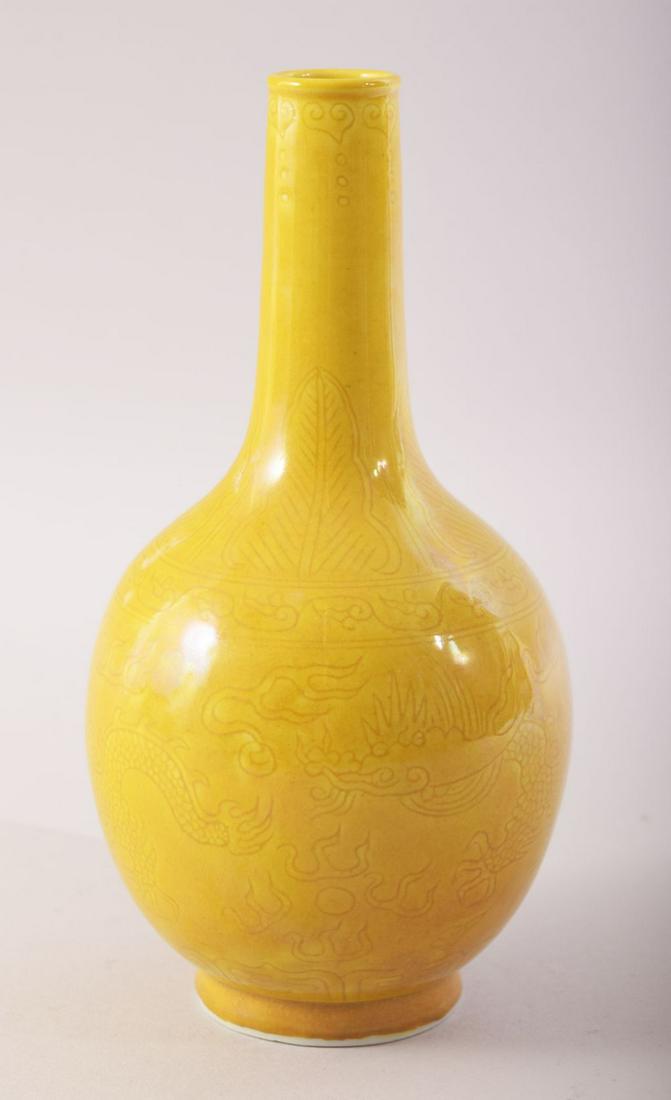 A SMALL CHINESE YELLOW GLAZE PORCELAIN BOTTLE VASE,: A SMALL CHINESE YELLOW GLAZE PORCELAIN BOTTLE VASE, incised under glaze with dragons and the flaming pearl of wisdom, mark to base, 17.5cm high.
