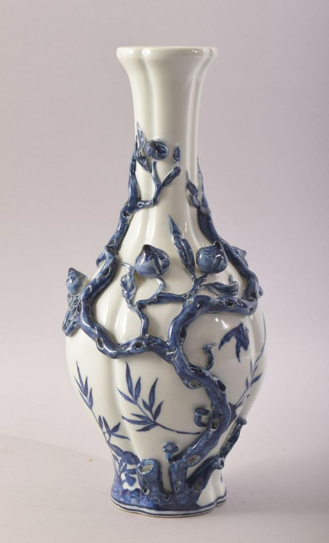 A CHINESE BLUE AND WHITE PORCELAIN VASE, with moulded: A CHINESE BLUE AND WHITE PORCELAIN VASE, with moulded relief peach tree decoration, the body with bats, mark to base, 31cm high.