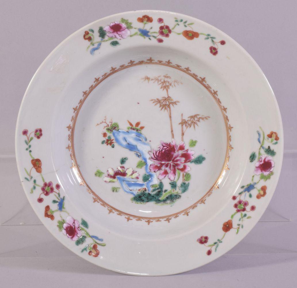 A CHINESE FAMILLE ROSE PORCELAIN SOUP DISH, the centre: A CHINESE FAMILLE ROSE PORCELAIN SOUP DISH, the centre painted with native flora and with gilt highlights, 23cm diameter.