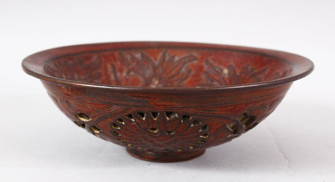 A CHINESE PIERCED POTTERY BOWL - the interior decorated: A CHINESE PIERCED POTTERY BOWL - the interior decorated with scenes of flora, the underside with pierced openwork style roundel's, 18cm