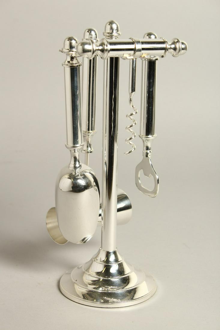 A SILVER PLATED FOUR PIECE BAR TOOLS SET on a stand.: A SILVER PLATED FOUR PIECE BAR TOOLS SET on a stand.