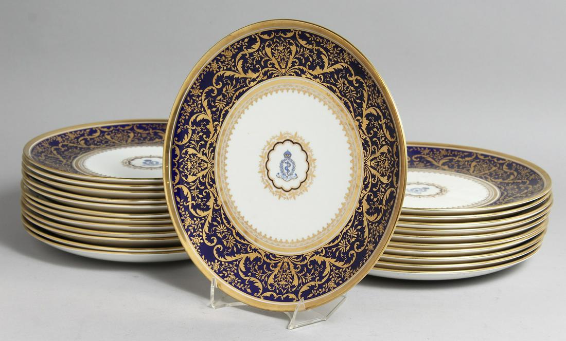 A SUPERB SET OF TWENTY THREE COALPORT PLATES with A M D crest and fine blue and gold border.: A SUPERB SET OF TWENTY THREE COALPORT PLATES with A M D crest and fine blue and gold border.