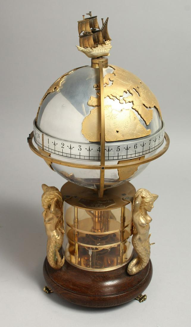 A GOOD ST JAMES HOUSE COMMEMORATIVE ANNULAR CLOCK, Circa. 1984, No. 181/1500. The globe revolves,: A GOOD ST JAMES HOUSE COMMEMORATIVE ANNULAR CLOCK, Circa. 1984, No. 181/1500. The globe revolves, with three gilt mermaid supports. 14.5ins high.