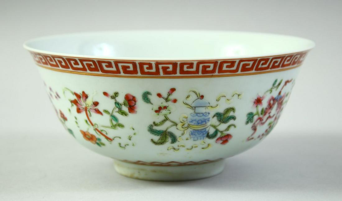A CHINESE FAMILLE ROSE PORCELAIN BOWL, decorated with symbolic emblems and with greek key band to: A CHINESE FAMILLE ROSE PORCELAIN BOWL, decorated with symbolic emblems and with greek key band to rim, six character mark to base, 15cm diameter.