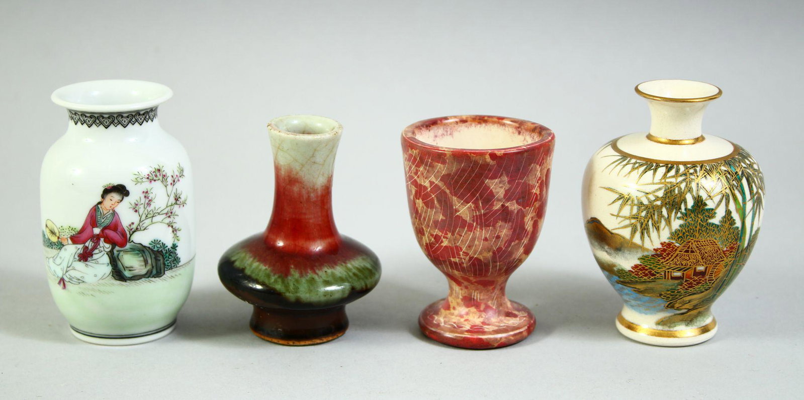 THREE SMALL PORCELAIN VASES, including one satsuma vase, one famille rose vase, another small red: THREE SMALL PORCELAIN VASES, including one satsuma vase, one famille rose vase, another small red vase with wax seal to base, together with an unusual footed cup, (4).