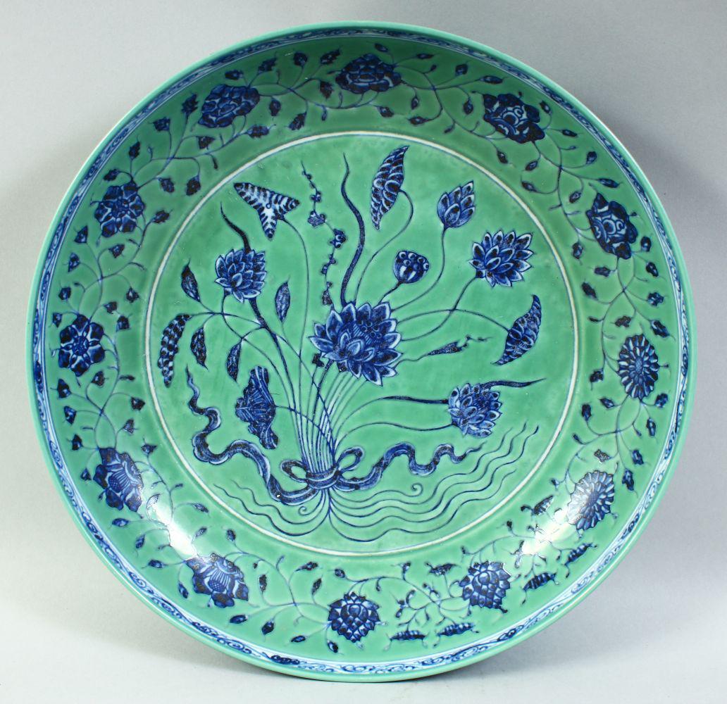 A LARGE CHINESE TURQUOISE GROUND PORCELAIN DISH, the centre painted with a floral spray surrounded: A LARGE CHINESE TURQUOISE GROUND PORCELAIN DISH, the centre painted with a floral spray surrounded by a border of further foliate decoration, 34cm diameter.