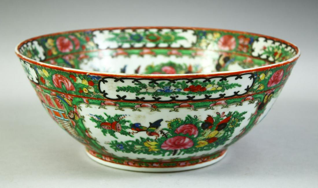 A CHINESE CANTON FAMILLE ROSE PORCELAIN BOWL, painted with panels of figures, birds and native: A CHINESE CANTON FAMILLE ROSE PORCELAIN BOWL, painted with panels of figures, birds and native flora, 28cm diameter.