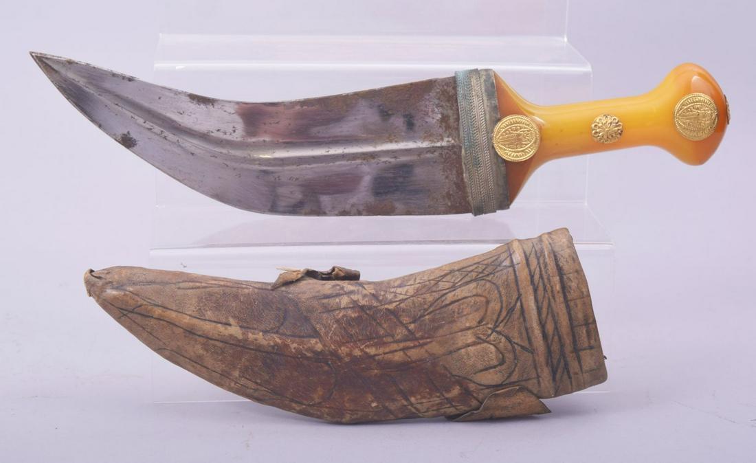 A RARE ISLAMIC ARAB JAMBIYA DAGGER, with gold mounted amber colour bakelite handle and original: A RARE ISLAMIC ARAB JAMBIYA DAGGER, with gold mounted amber colour bakelite handle and original scabbard, 33cm overall.