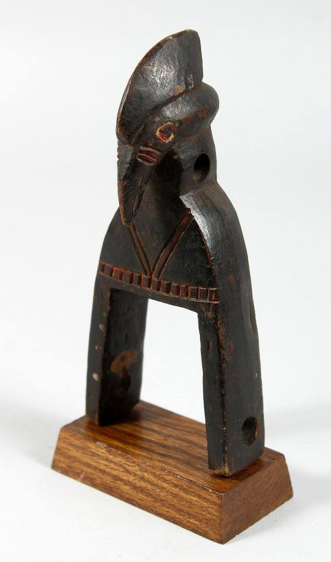 A CARVED WOOD TRIBAL BIRD'S HEAD PULLEY. 7.5ins high.: A CARVED WOOD TRIBAL BIRD'S HEAD PULLEY. 7.5ins high.