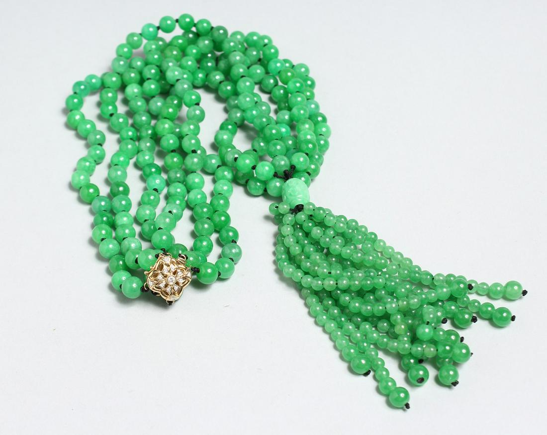 A LONG STRING OF JADE BEADS with 18ct and diamond clasp.: A LONG STRING OF JADE BEADS with 18ct and diamond clasp.