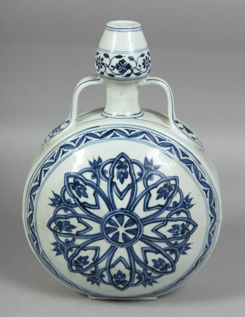 A CHINESE BLUE AND WHITE PORCELAIN TWIN HANDLE MOON FLASK, the central decorative motif with yin: A CHINESE BLUE AND WHITE PORCELAIN TWIN HANDLE MOON FLASK, the central decorative motif with yin yang symbol, six character mark below the rim, 30.5cm high.