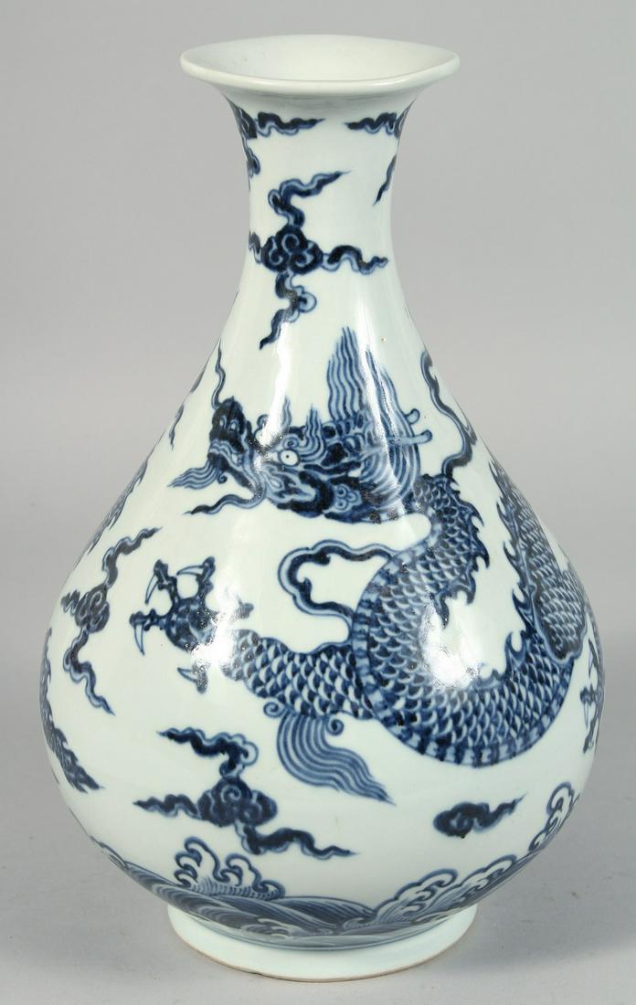 A CHINESE BLUE AND WHITE PORCELAIN YUHUCHUNPIN VASE, the body decorated with a large dragon amongst: A CHINESE BLUE AND WHITE PORCELAIN YUHUCHUNPIN VASE, the body decorated with a large dragon amongst stylised clouds above a band of waves, 31cm high.