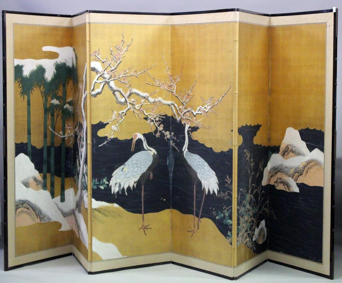 A JAPANESE LATE MEIJI SIX PANEL FOLDING SCREEN, with gold paper background and painted continuous: A JAPANESE LATE MEIJI SIX PANEL FOLDING SCREEN, with gold paper background and painted continuous scene of a river landscape with a pair of cranes, prunus trees and bamboo, each panel 172cm x 62cm.
