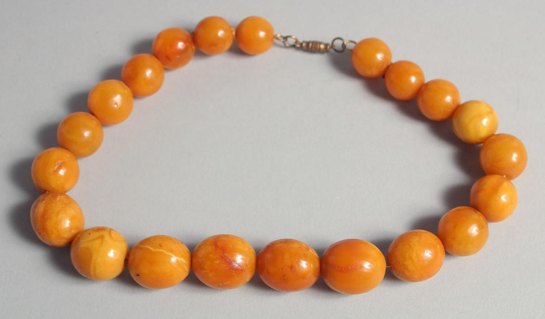 AN AMBER BEADED NECKLACE, with graduating beads, largest approx. 23mm. (1 of 3)