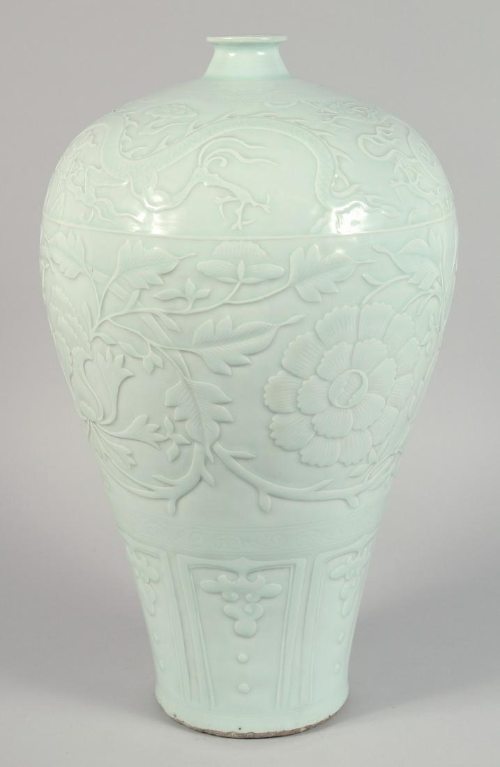 A VERY LARGE CELADON GLAZE PORCELAIN MEIPING VASE, the body with carved decoration depicting large (1 of 6)