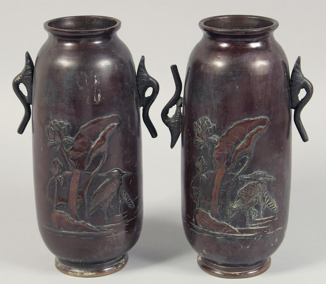 A PAIR OF JAPANESE TWIN-HANDLED BRONZE VASES with relief decoration depicting cranes. 25cm high. (1 of 6)