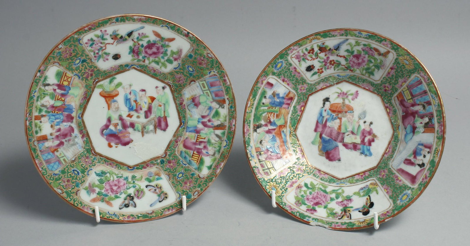 TWO CHINESE CANTON FAMILLE ROSE PORCELAIN DISHES, painted with a central panel of figures as well as: TWO CHINESE CANTON FAMILLE ROSE PORCELAIN DISHES, painted with a central panel of figures as well as panels of native flora and fauna, 19cm and 18.5cm diameter, (2).