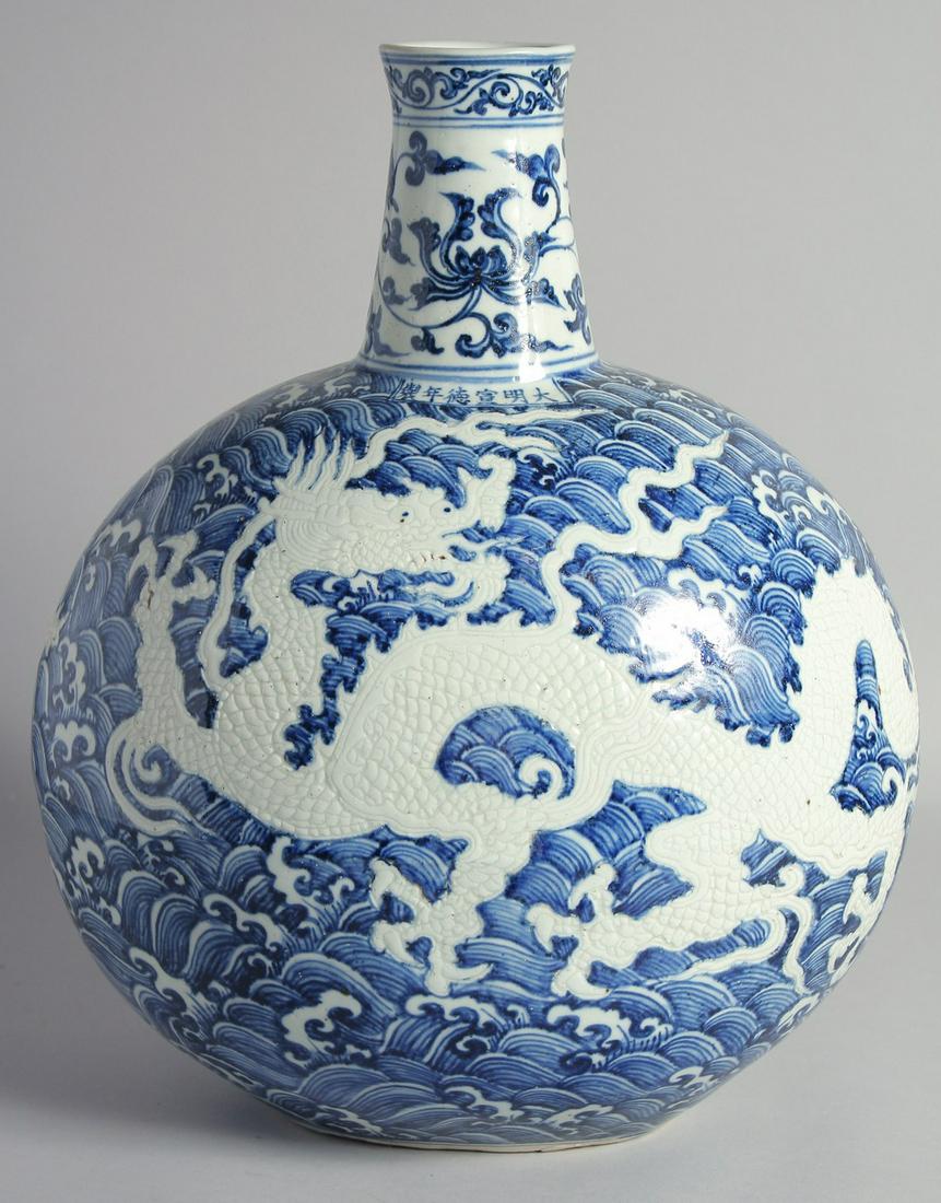 A LARGE CHINESE BLUE AND WHITE PORCELAIN MOON FLASK VASE, decorated with a large incised dragon in (1 of 7)