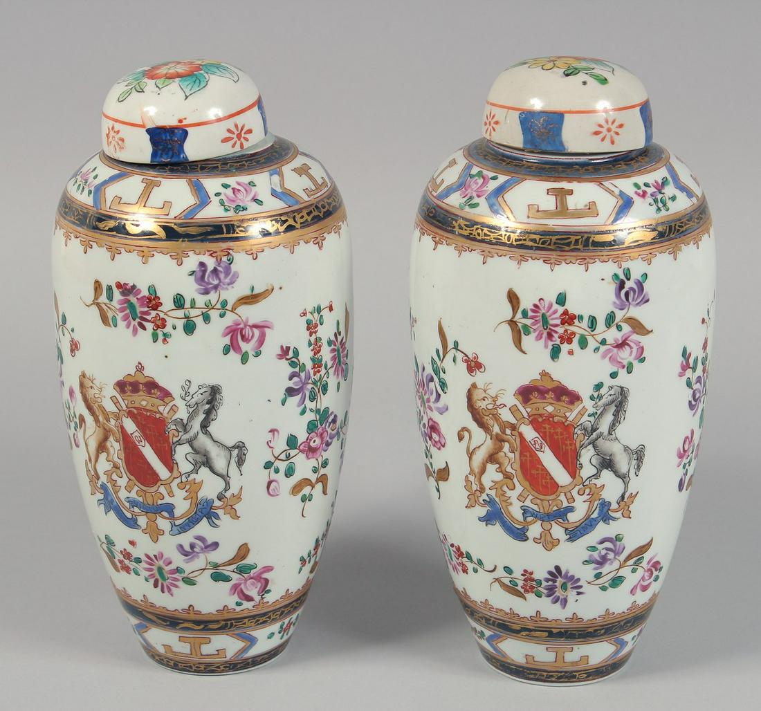 A PAIR OF SAMSON FAMILLE ROSE PORCELAIN VASES AND COVERS, each with central crest and floral: A PAIR OF SAMSON FAMILLE ROSE PORCELAIN VASES AND COVERS, each with central crest and floral decoration, both with marks to base. 23cm high
