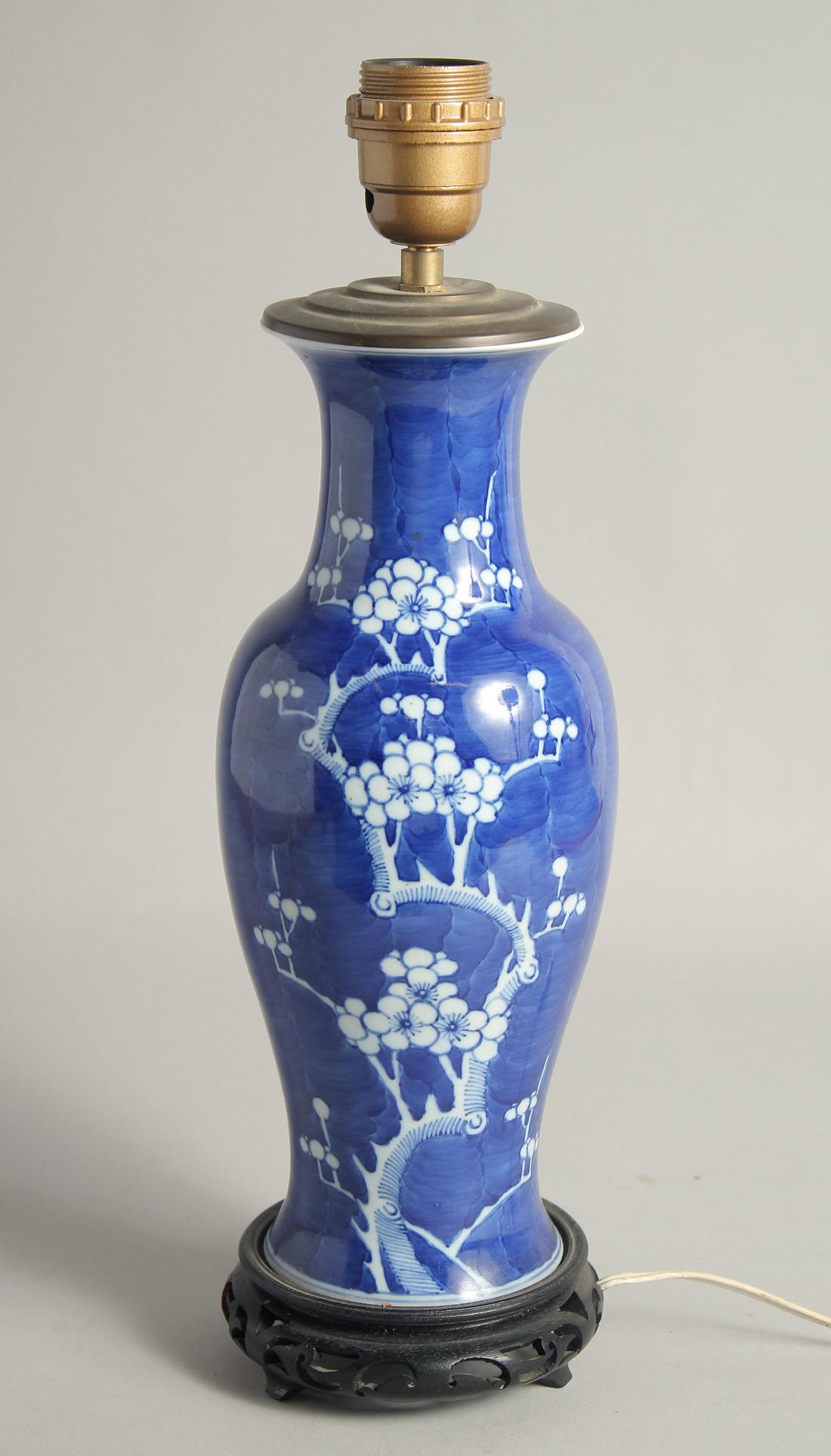 A CHINESE BLUE AND WHITE PORCELAIN PRUNUS VASE / LAMP, mounted to a wooden base, 42cm high overall.: A CHINESE BLUE AND WHITE PORCELAIN PRUNUS VASE / LAMP, mounted to a wooden base, 42cm high overall.