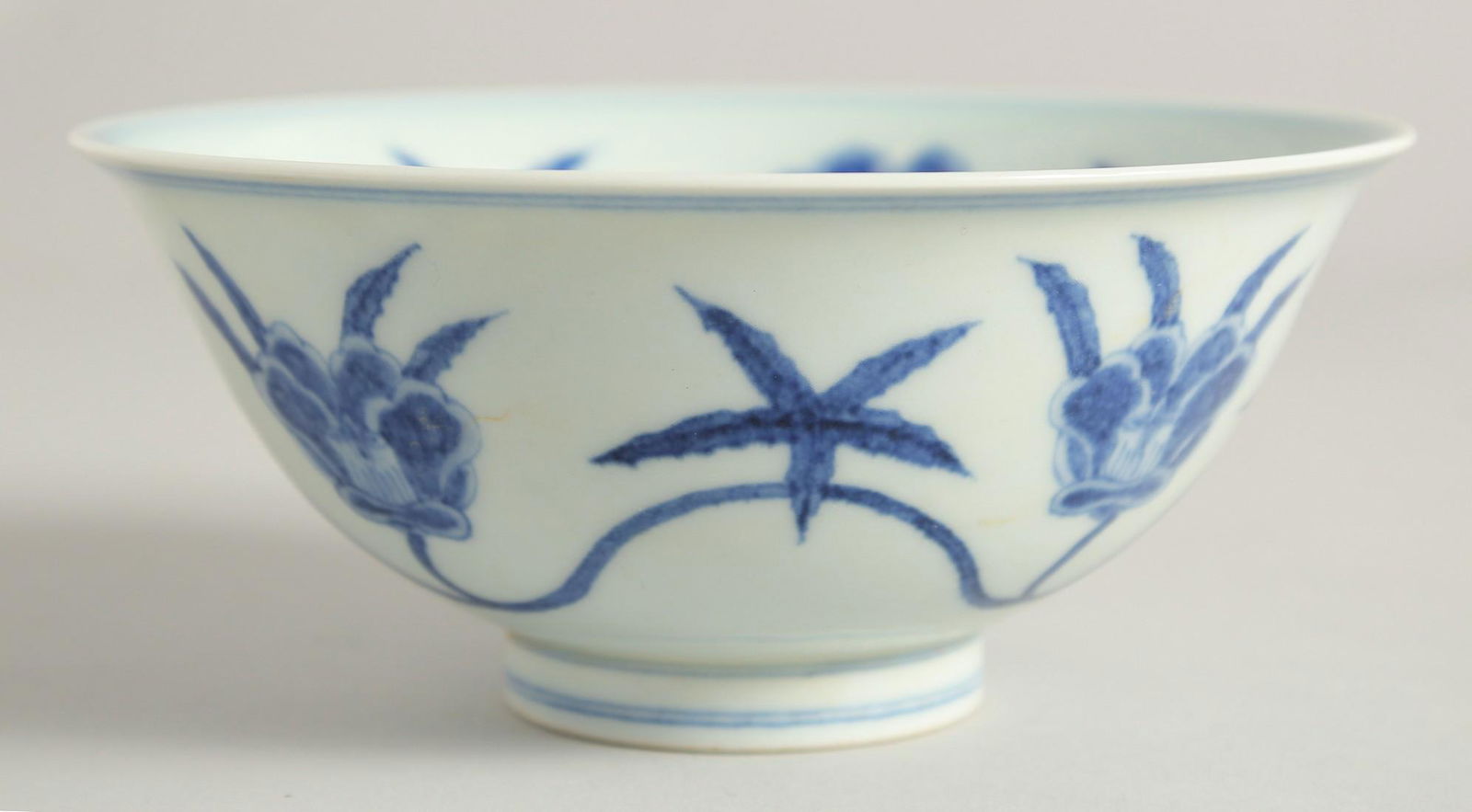 A CHINESE BLUE AND WHITE PORCELAIN BOWL, with floral decoration the exterior and interior, the base: A CHINESE BLUE AND WHITE PORCELAIN BOWL, with floral decoration the exterior and interior, the base with six-character mark, 15cm diameter.