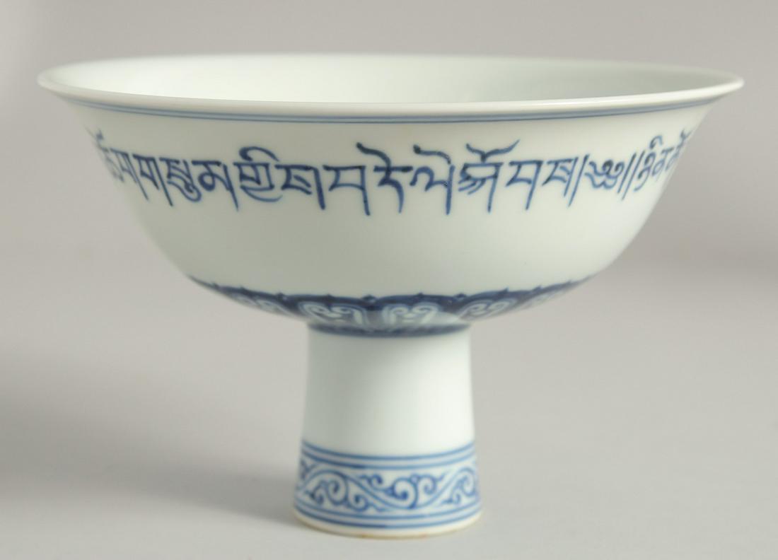 A CHINESE BLUE AND WHITE PORCELAIN PEDESTAL BOWL, the exterior with a band of characters, the: A CHINESE BLUE AND WHITE PORCELAIN PEDESTAL BOWL, the exterior with a band of characters, the interior centre with faintly incised four-character mark, bowl 17.5cm diameter.