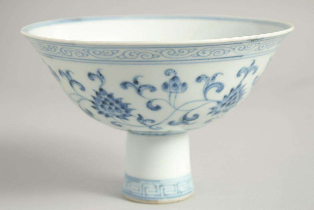 A CHINESE BLUE AND WHITE PORCELAIN PEDESTAL BOWL painted with lotus and vine decoration with: A CHINESE BLUE AND WHITE PORCELAIN PEDESTAL BOWL painted with lotus and vine decoration with six-character mark to inner foot rim. Bowl 17cm diameter