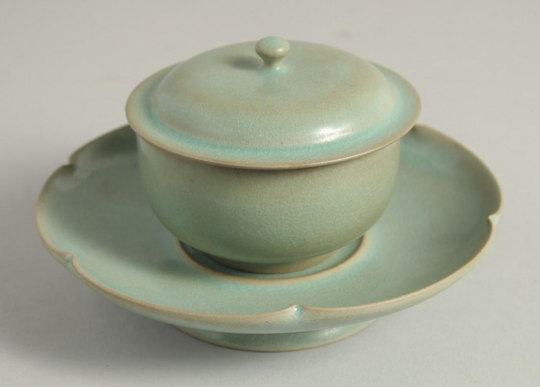 A CHINESE RUI-WARE STYLE CELADON PORCELAIN TEA SET, comprising a tea bowl and cover, with: A CHINESE RUI-WARE STYLE CELADON PORCELAIN TEA SET, comprising a tea bowl and cover, with petal-formed saucer. Cup 9cm diameter, saucer 17cm diameter (3)