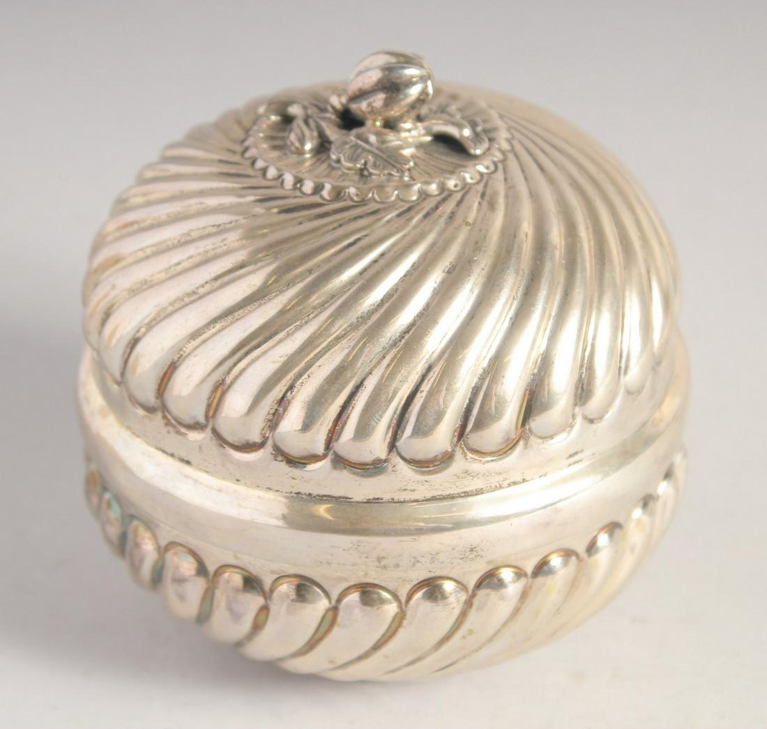 A SILVER CIRCULAR BOX AND COVER, the cover with naturalistic knop, ribbed decoration to the cover: A SILVER CIRCULAR BOX AND COVER, the cover with naturalistic knop, ribbed decoration to the cover and base, stamped 900, 11.5cm diameter, 300g.