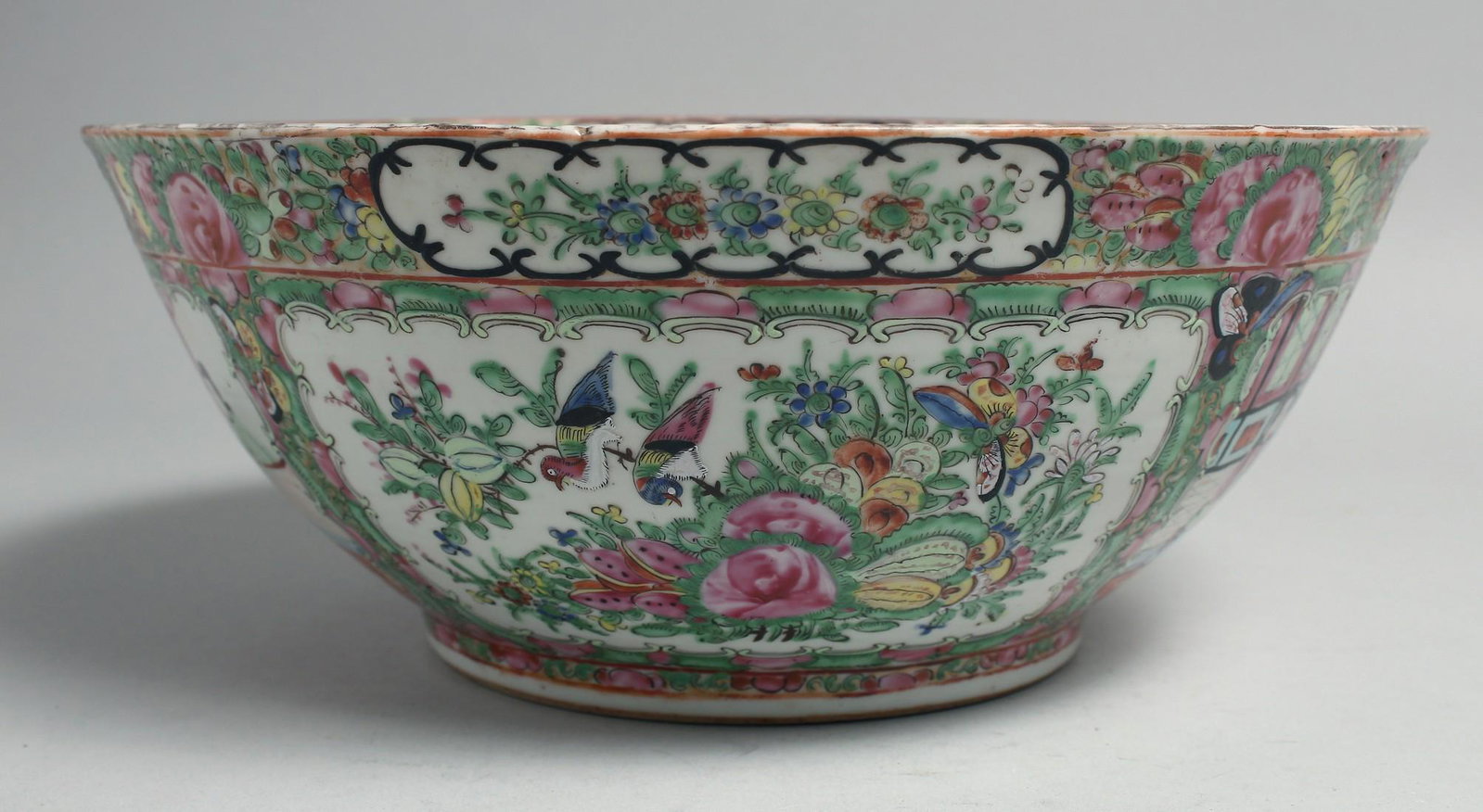 A CHINESE CANTON FAMILLE ROSE PORCELAIN BOWL, painted with panels of figures, birds and native: A CHINESE CANTON FAMILLE ROSE PORCELAIN BOWL, painted with panels of figures, birds and native flora, 27.5cm diameter.