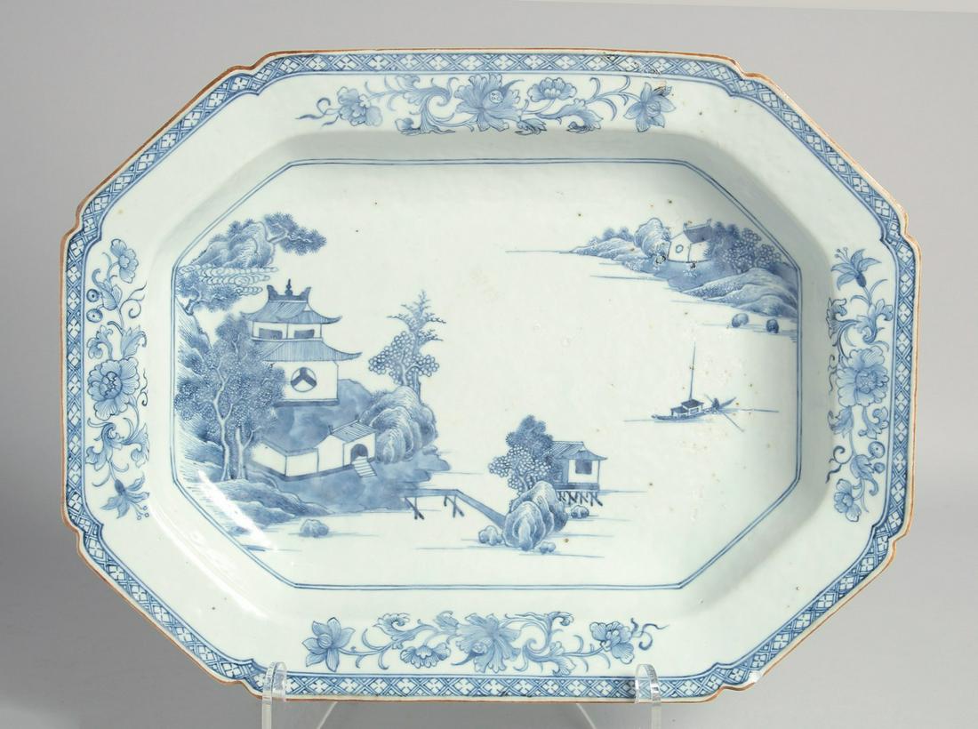 A CHINESE BLUE AND WHITE PORCELAIN SERVING DISH, painted with a landscape view over water with a: A CHINESE BLUE AND WHITE PORCELAIN SERVING DISH, painted with a landscape view over water with a border of floral motifs, 36.5cm 28.5cm.