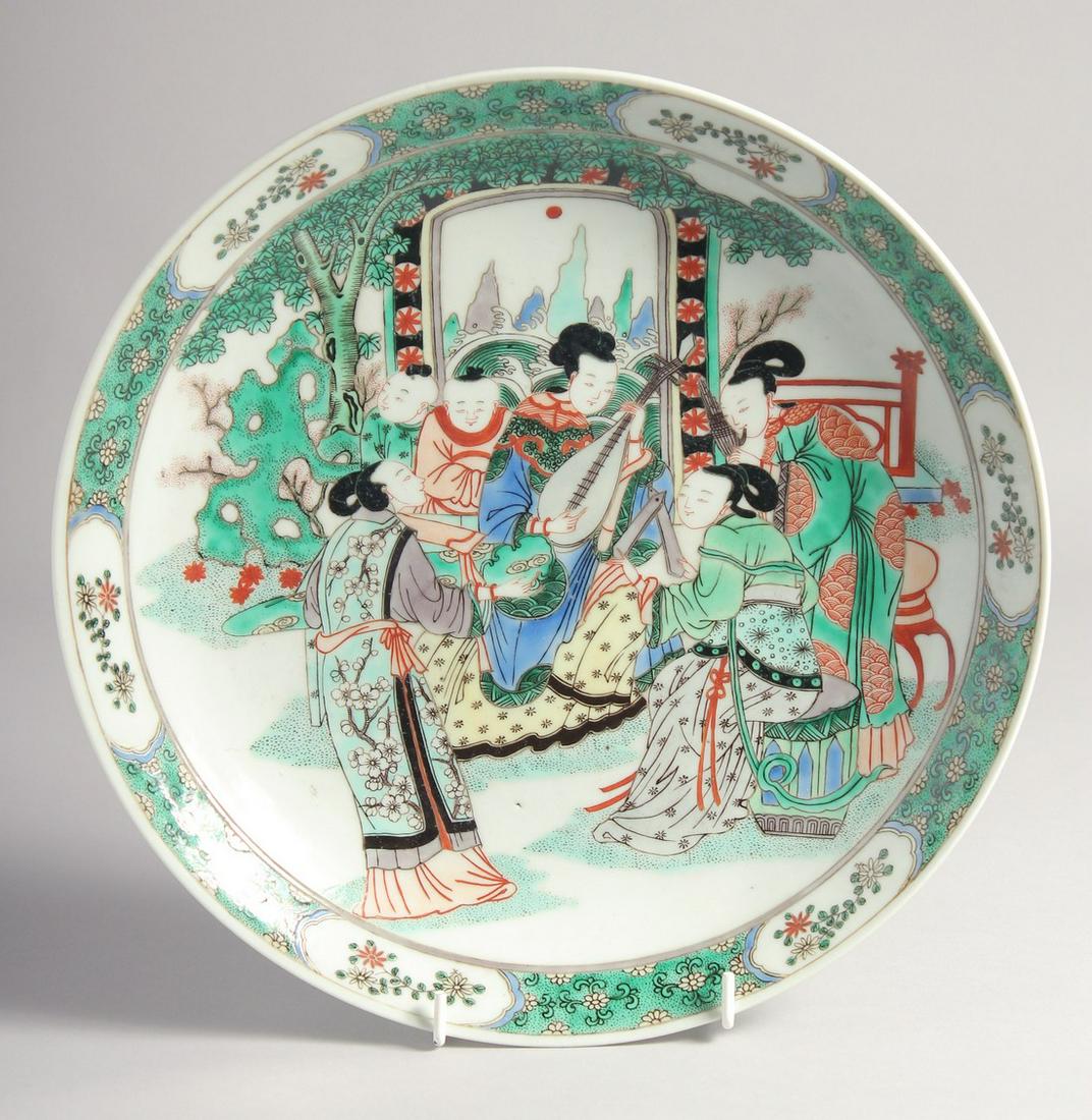 A CHINESE FAMILLE VERTE PORCELAIN PLATE, painted with a female figures playing musical instruments (1 of 4)