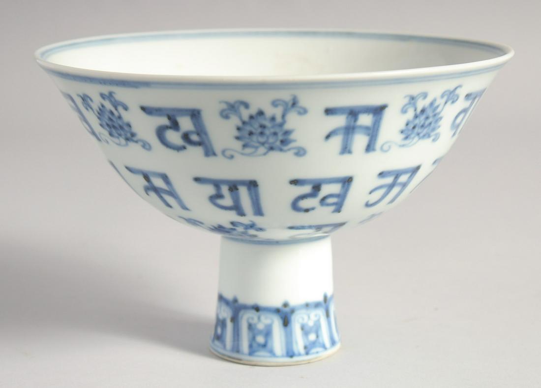 A CHINESE BLUE AND WHITE PORCELAIN STEM CUP painted with lotus and characters, the interior centre: A CHINESE BLUE AND WHITE PORCELAIN STEM CUP painted with lotus and characters, the interior centre with six-character mark, bowl 17cm diameter