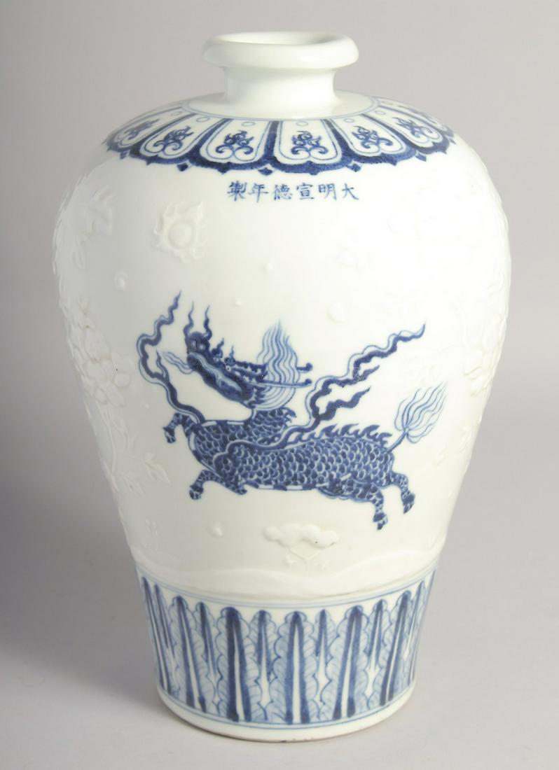 A CHINESE BLUE AND WHITE PORCELAIN MEIPING VASE painted with mythical beasts and carved with flora, (1 of 7)